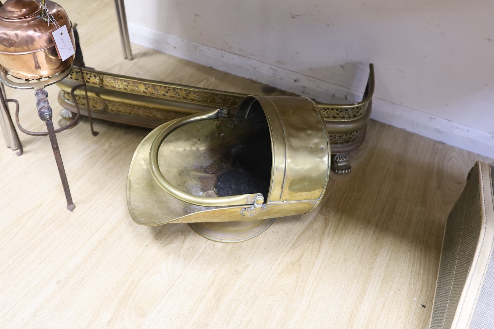 A copper kettle and trivet stand, a brass coal scuttle and a fender, Trivet 33 cms high.